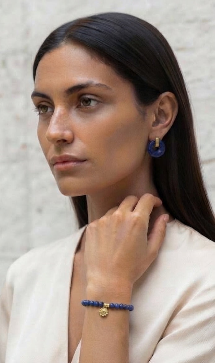 Modelo luciendo pulsera de lapislázuli con pendientes a juego