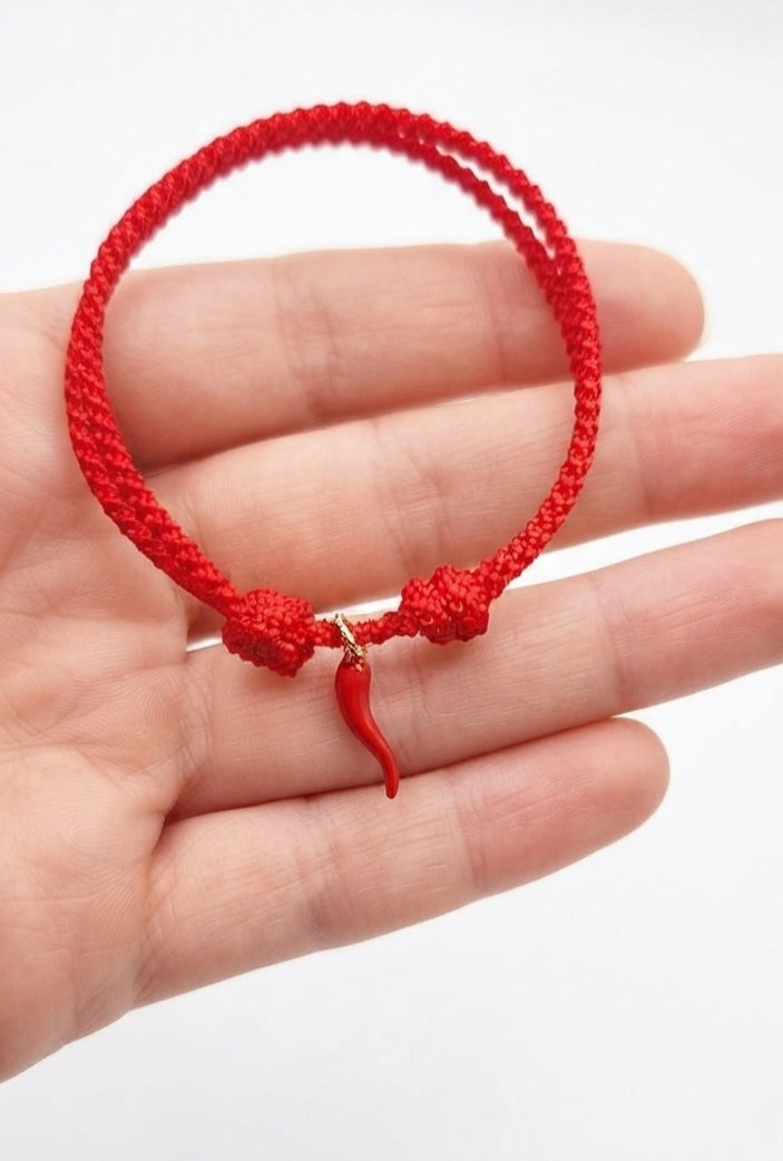 Pulsera cornicello cuerda roja ajustable - vista en mano fondo blanco