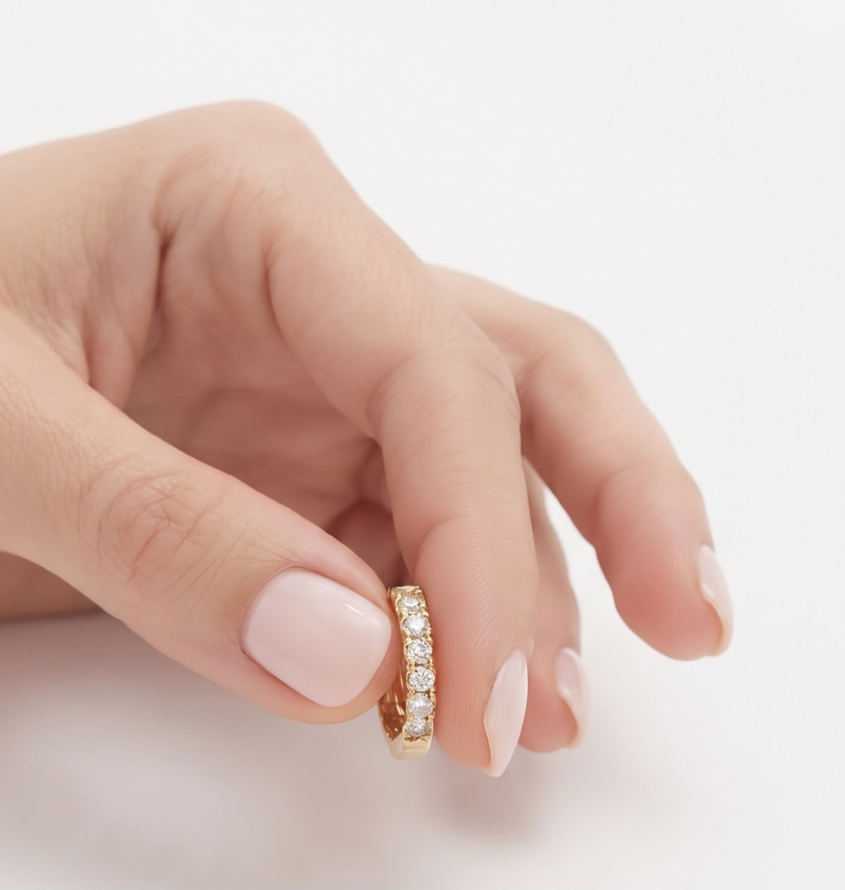 Aros mini circonitas dorados en mano detalle