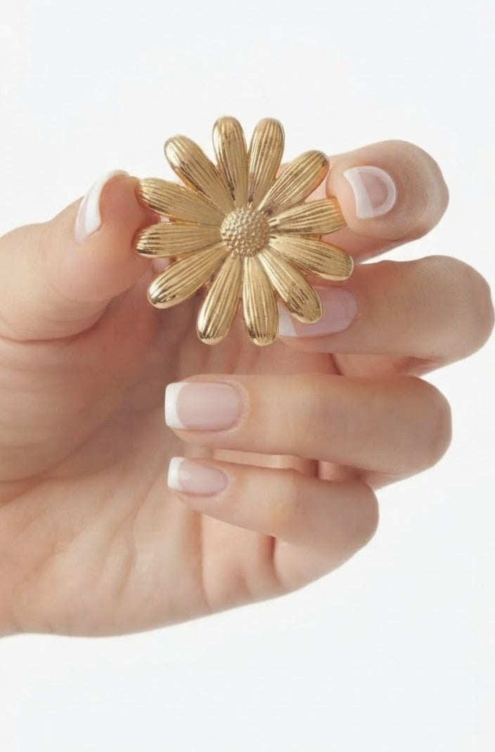 Broche margarita acero dorado en mano