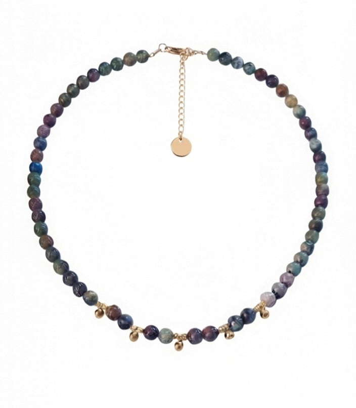 Collar de ágata india con entrepiezas doradas sobre fondo blanco