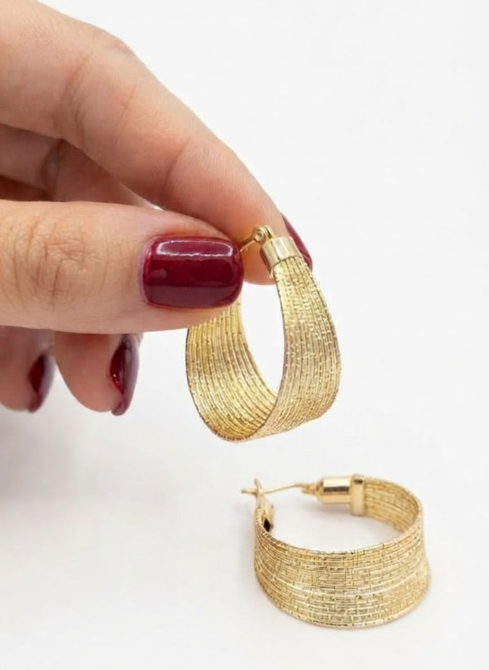 Aros anchos acero dorado textura rafia en mano