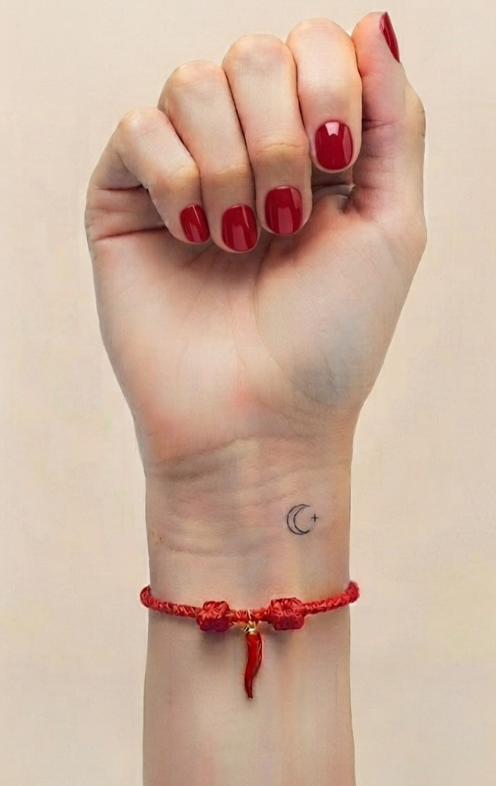 Pulsera cornicello roja puesta en muñeca izquierda