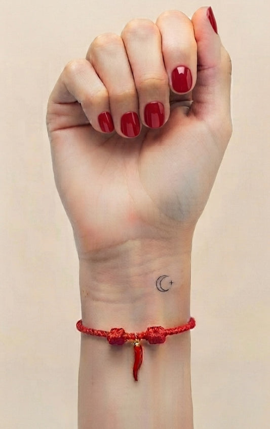 Pulsera cornicello roja puesta en muñeca izquierda