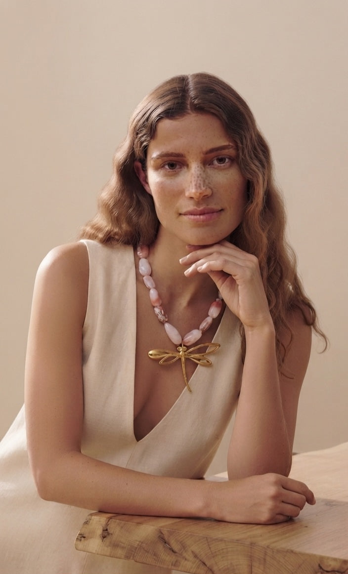 Collar resina rosa con libélula dorada puesto en modelo