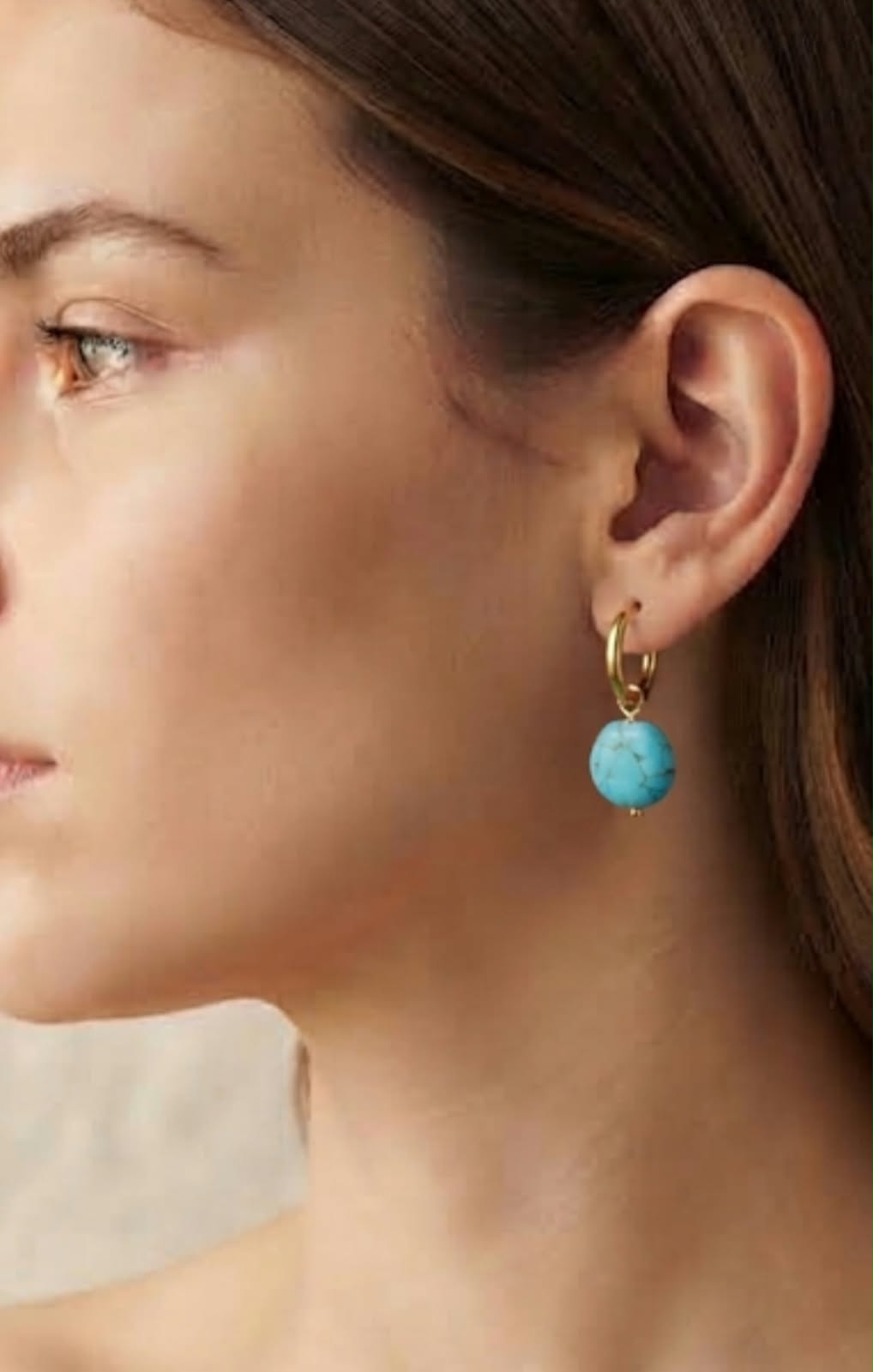 Pendiente aro dorado con turquesa howlita puesto en modelo, vista de perfil