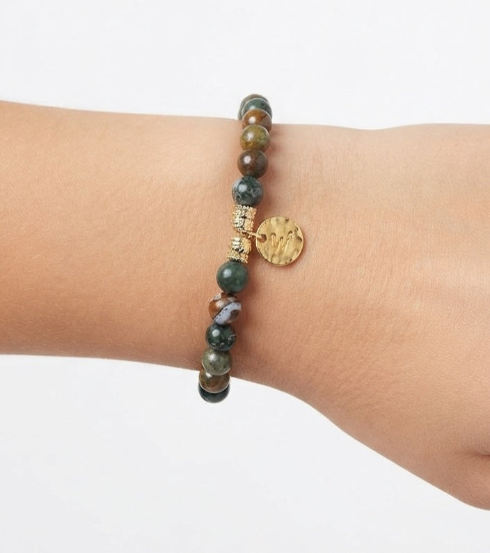 Modelo luciendo pulsera de ágata india con moneda dorada en muñeca