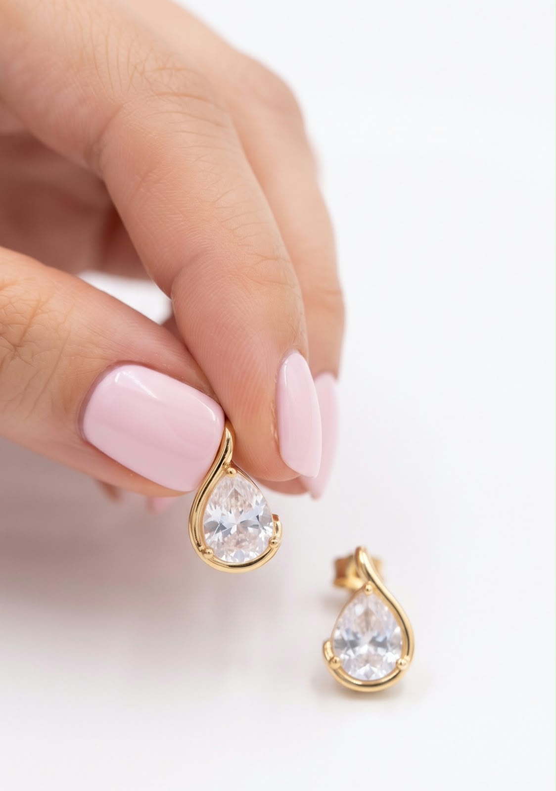 Pendientes gota circonita dorada en mano detalle