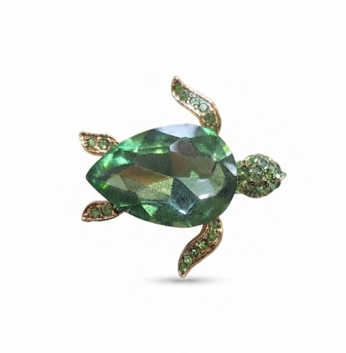 Broche tortuga cristal verde sostenido en mano - escala real