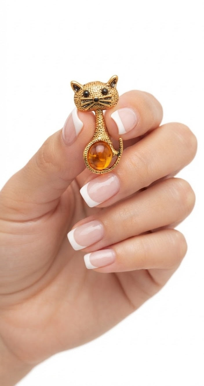 Broche gatito dorado con ámbar en mano