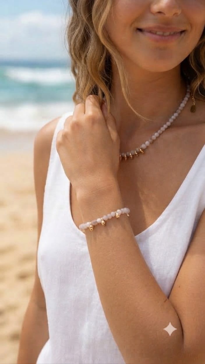 Modelo luciendo collar de ópalo rosa con pepitas doradas en la playa