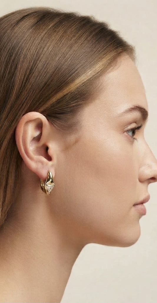 Modelo luciendo pendientes aro piedra triangular dorado