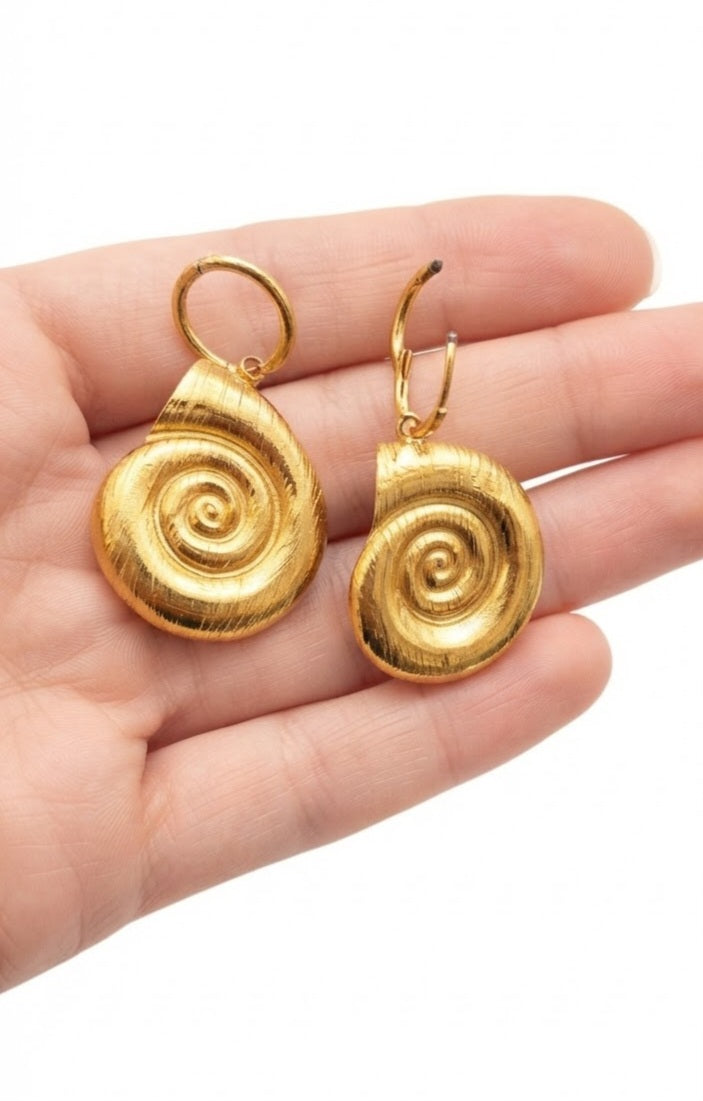 Modelo luciendo pendientes amonite dorado
