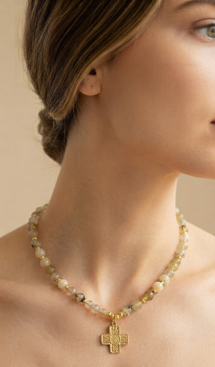 Collar ópalo amarillo con cruz dorada puesto en modelo