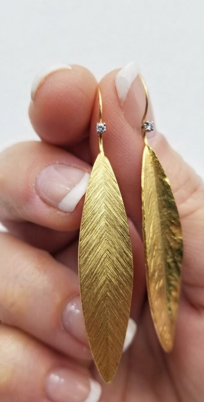 Pendientes hoja acero dorado en mano