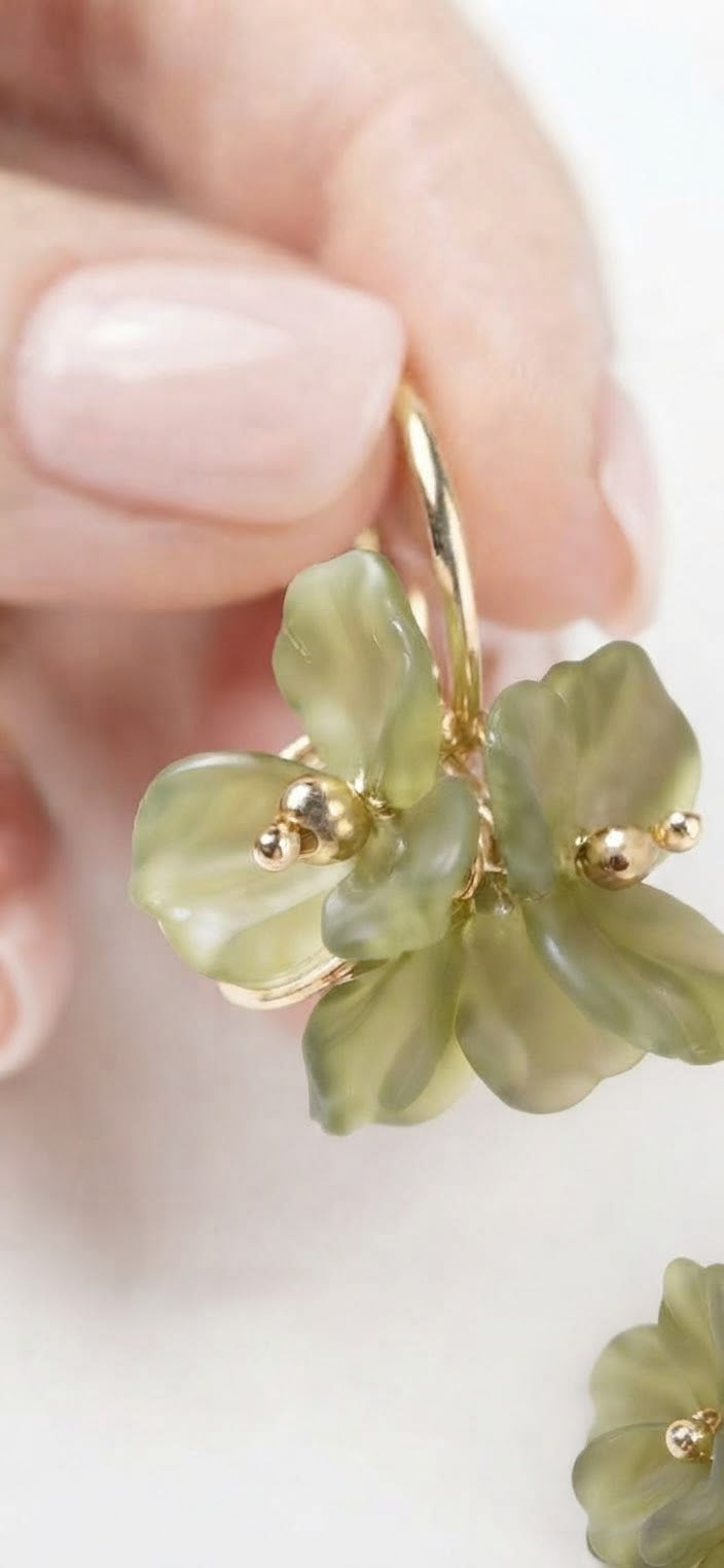 Pendientes aro dorado flor verde acrílica detalle en mano