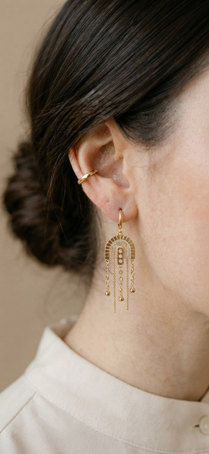 Detalle pendiente arco flecos dorado en oreja