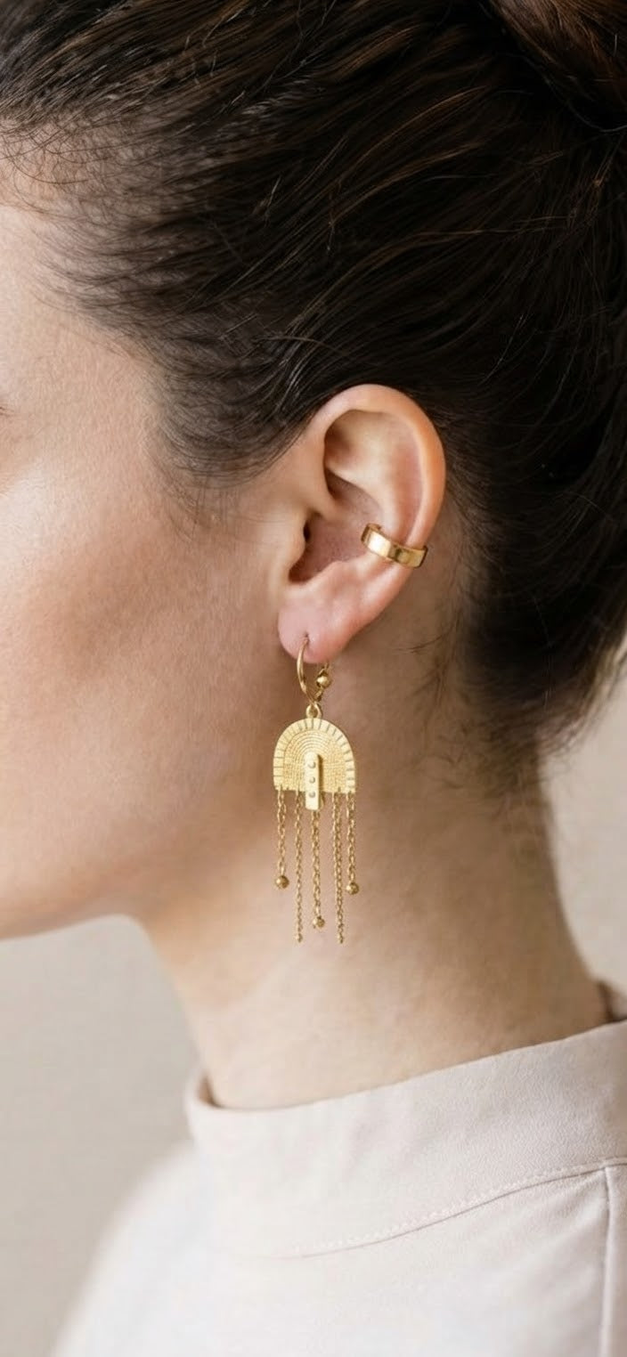 Modelo luciendo pendientes arco flecos dorado