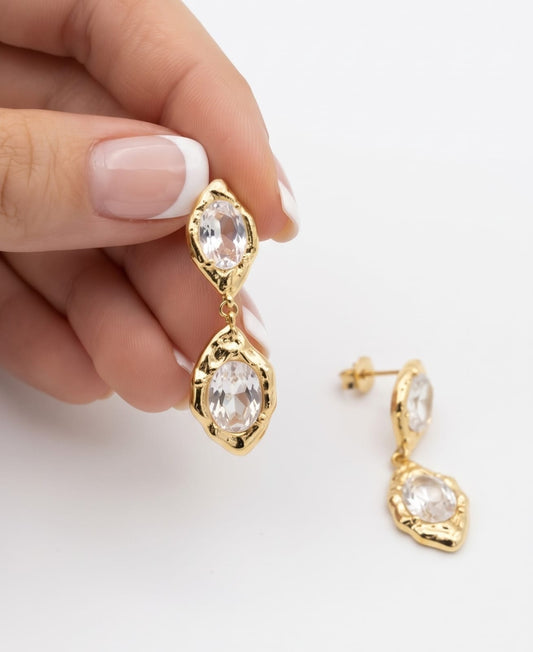 Pendientes colgantes dobles circonita dorado - detalle en mano
