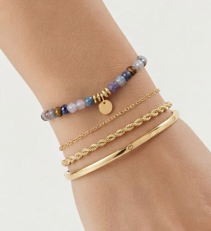 Detalle pulsera piedras semipreciosas multicolor con charm dorado en muñeca