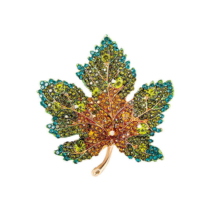 Broche hoja de arce cristales multicolor sobre fondo blanco