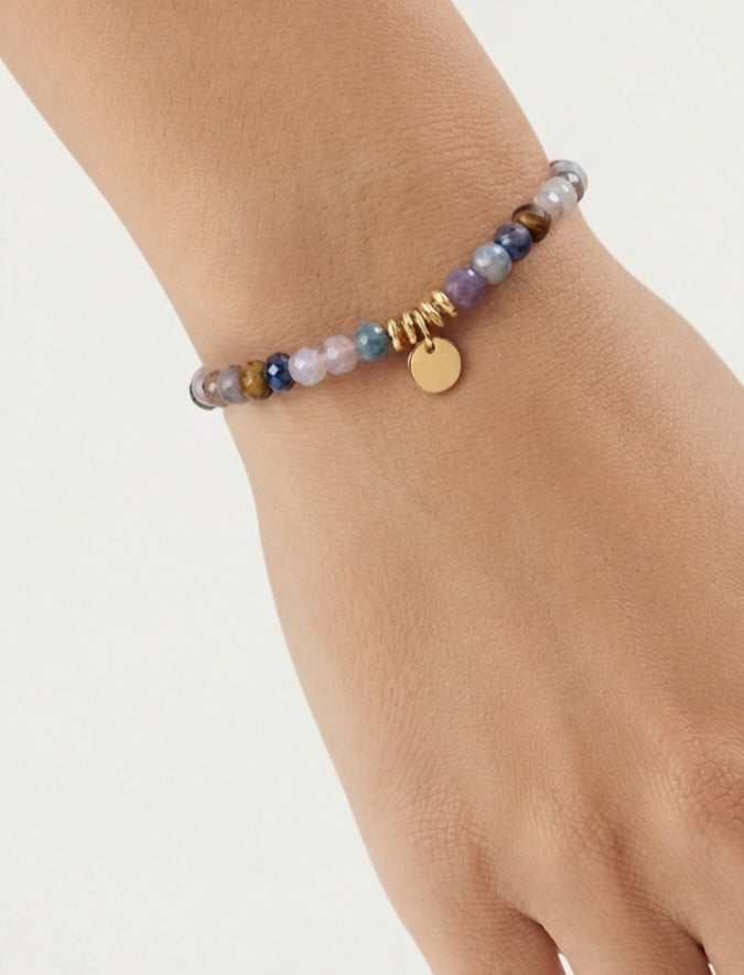 Pulsera piedras semipreciosas multicolor con charm dorado puesta en muñeca en stack