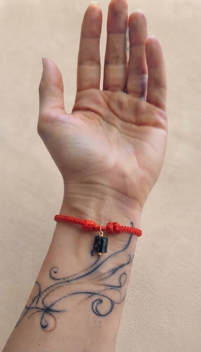 Pulsera cordón rojo turmalina negra puesta en muñeca izquierda